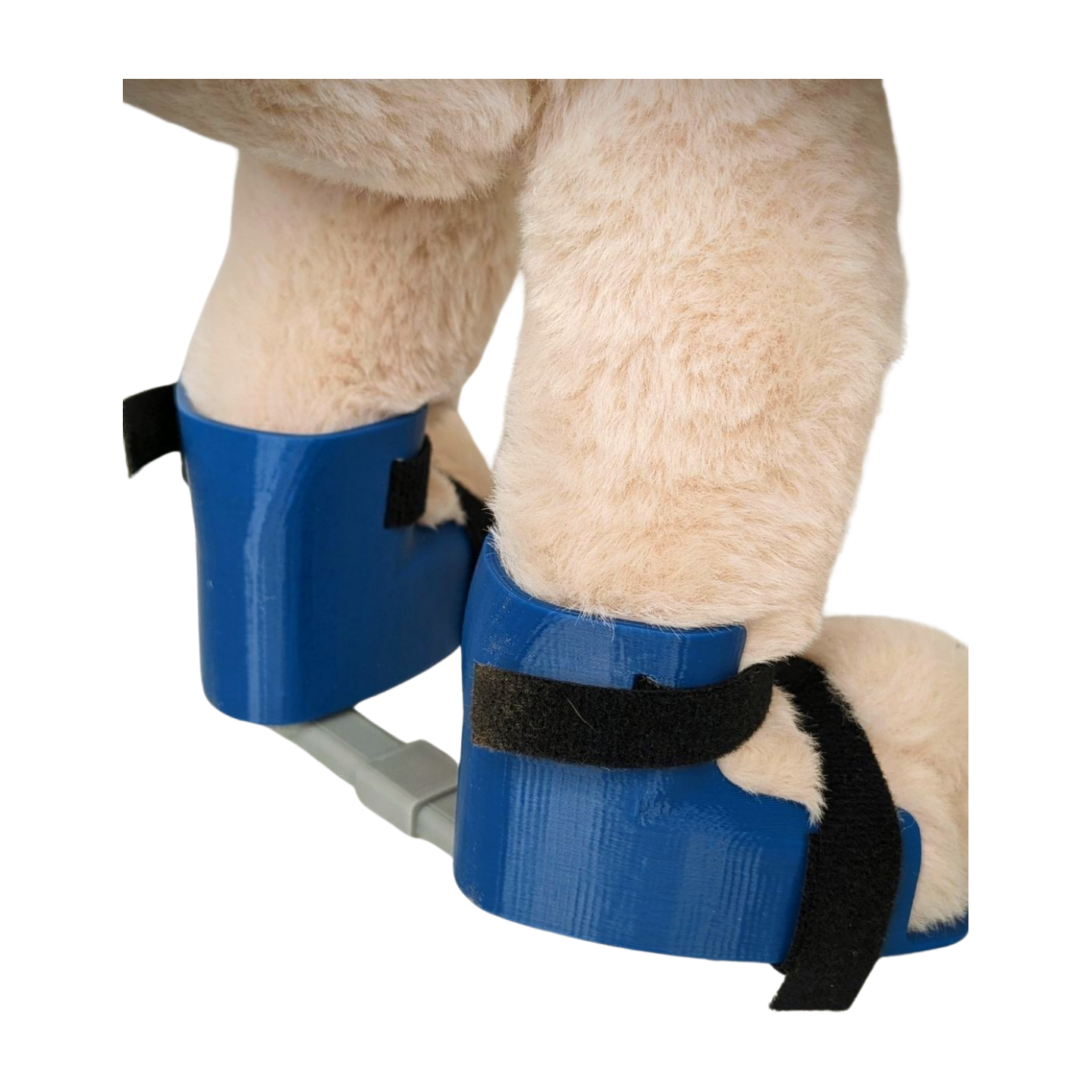 Back view of plush bunny with blue Ponseti-style clubfoot brace showing boot shape and bar width.