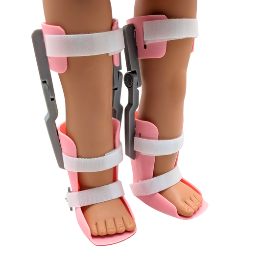 Doll-sized KAFO leg braces designed for 18-inch dolls, white Velcro straps and gray alignment guides.
